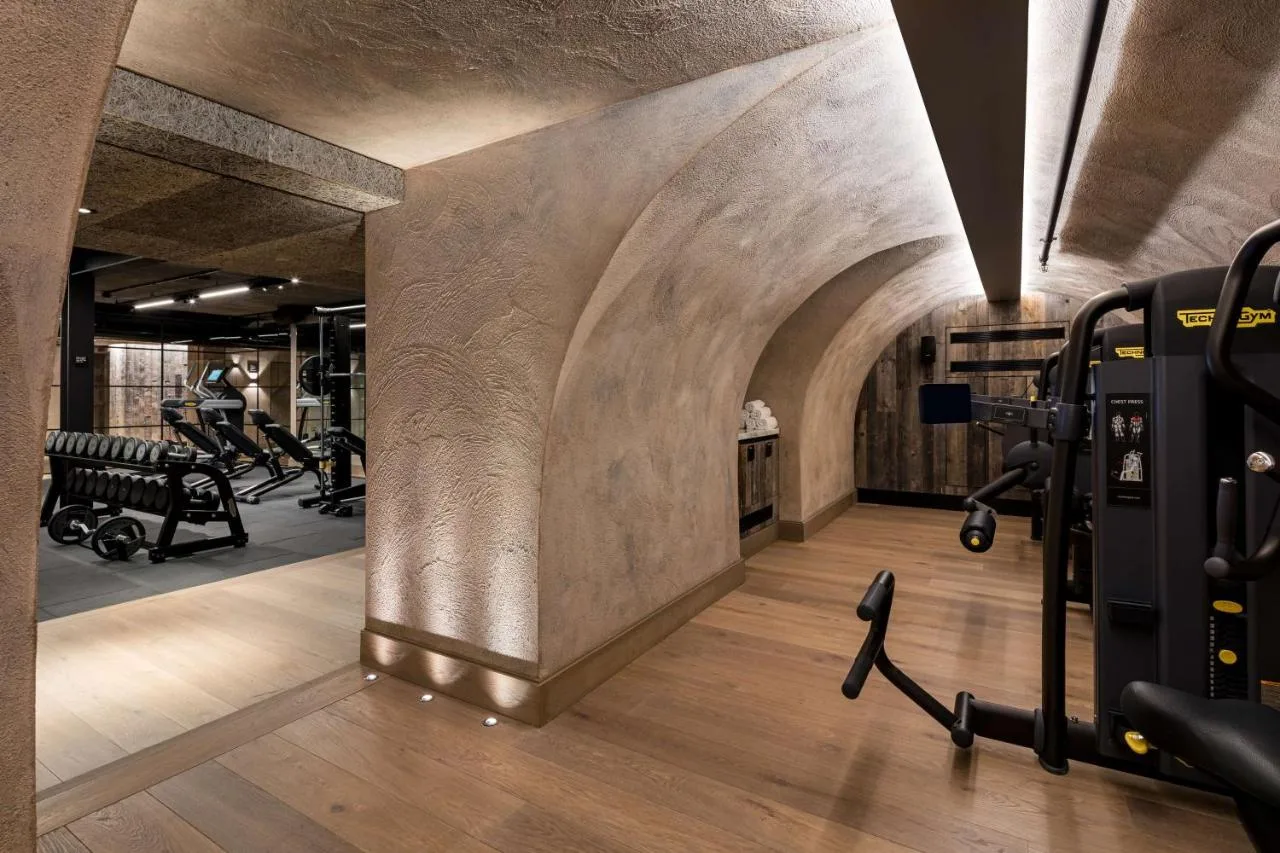 Gym with exercise equipment and stone wall at The Edwardian Manchester